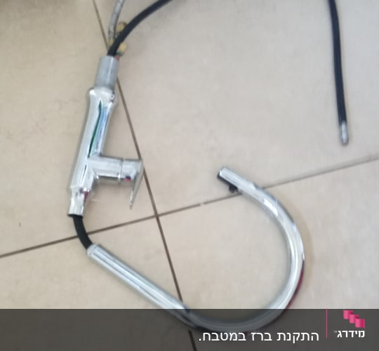ברז מטבח מנותק עם צינור גמיש על הרצפה